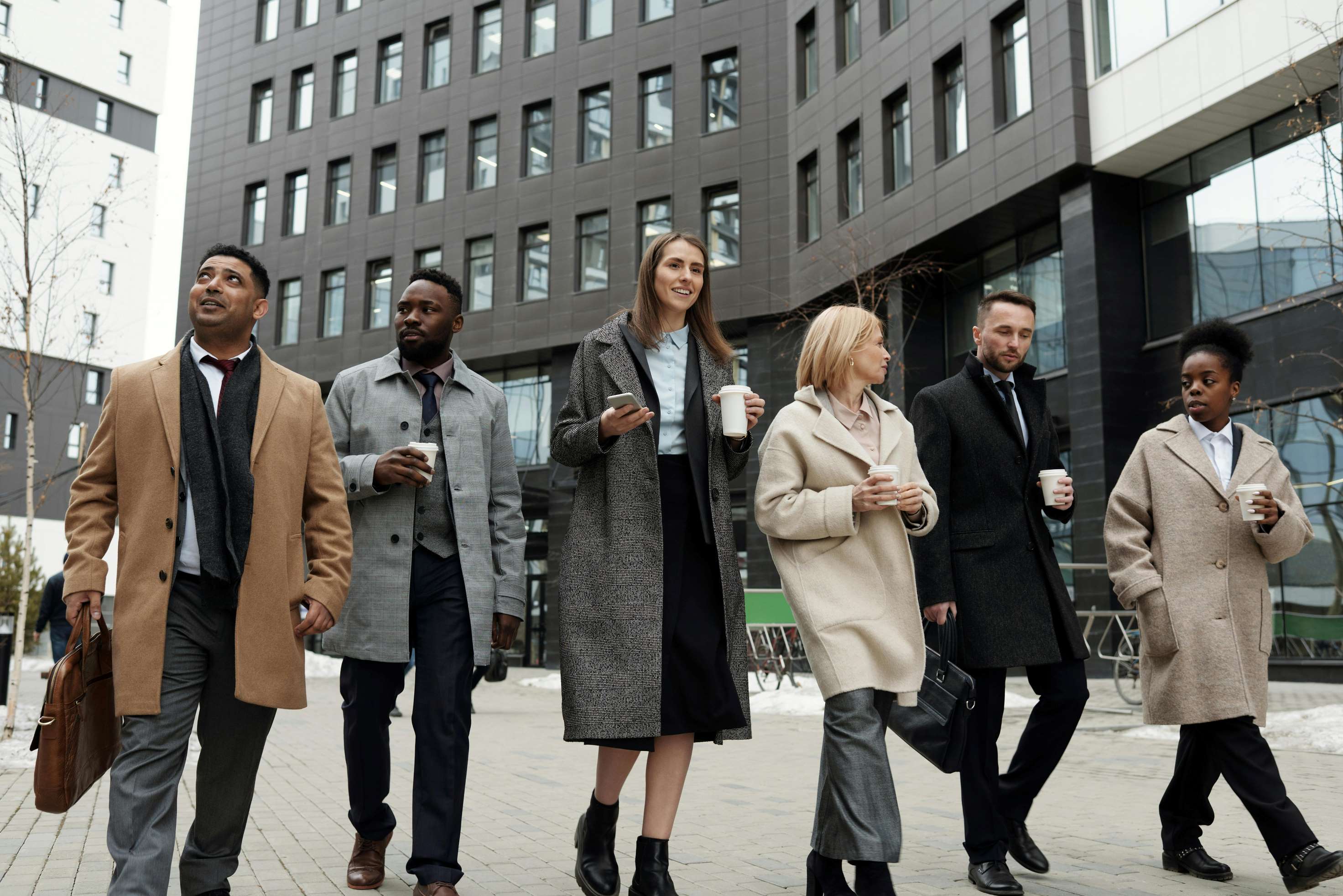 group of people walking in front of a building.