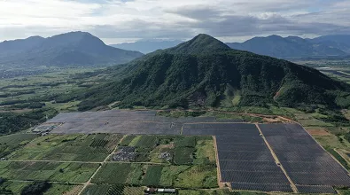 green mountain with solar panels at its base