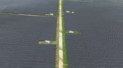long road, seen from air, lined with solar panels