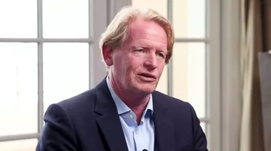 middle aged man with white hair in a suit