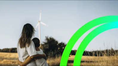 woman and child hugging, and a wind turbine in the background.