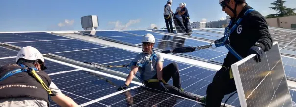 Men installing solar panels on top of a roof