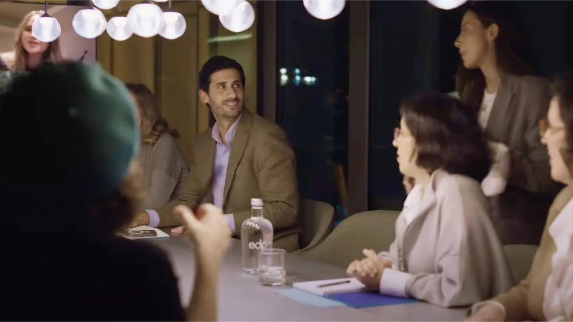 group of eight employees gathered in a meeting room and socialising