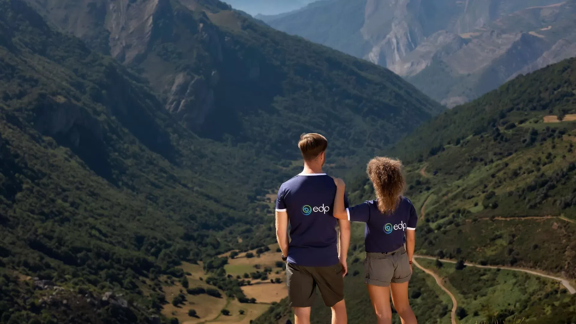 A man and a women with dark blue t-shirts with EDP's logo looking to a mountains' valley