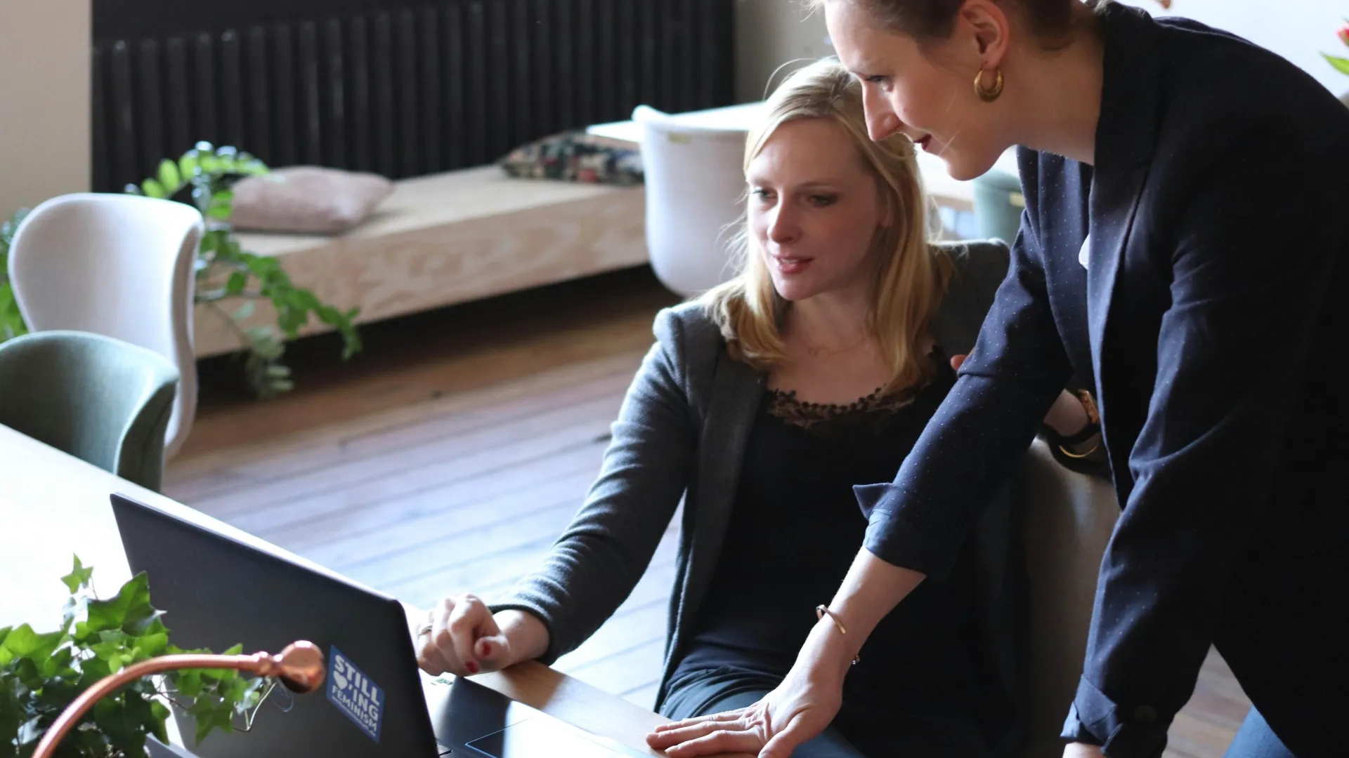 two people looking at a laptop screen.