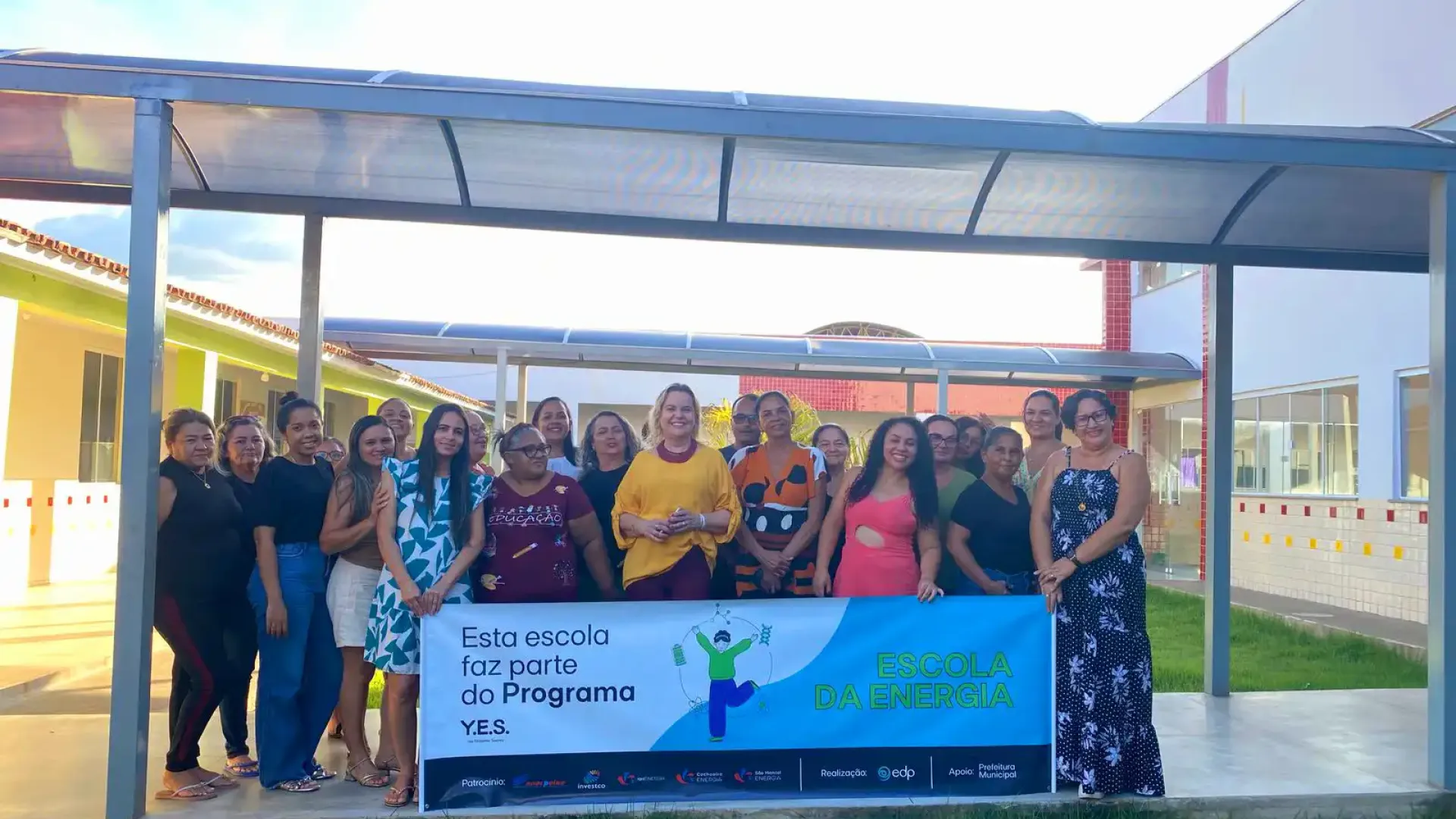 Professores posam com a placa da Escola da Energia