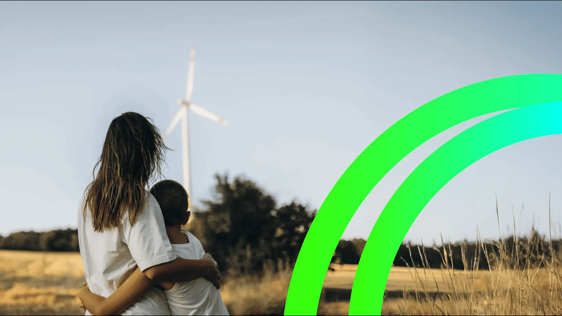 woman and child hugging, and a wind turbine in the background.