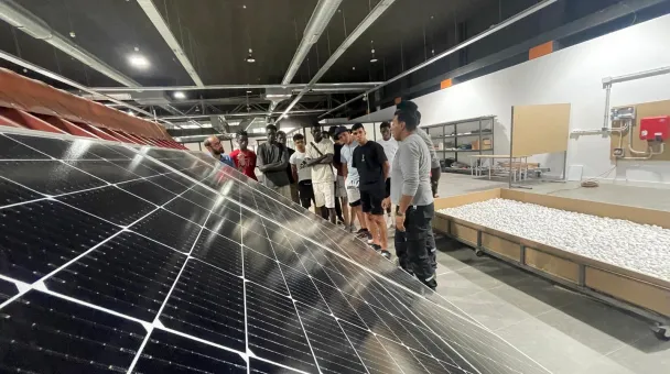 Group of people in front of solar panels