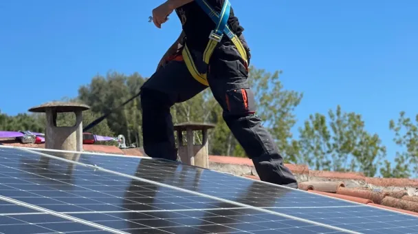 Man on roof installing solar panels