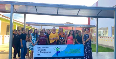 Professores posam com a placa da Escola da Energia