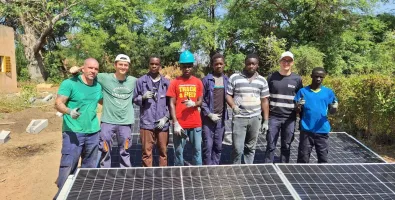 kids standing next to a solar panel