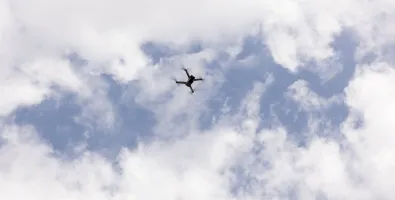 drone flying with clouds in the background.