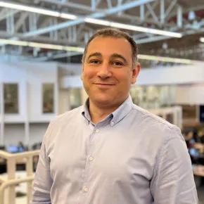 Em foco, Eduardo Pedro Silva, caucasiano, de camisa branca e fundo desfocado com as instalações internas da EDP no Brasil