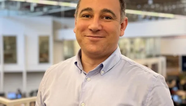 Em foco, Eduardo Pedro Silva, caucasiano, de camisa branca e fundo desfocado com as instalações internas da EDP no Brasil