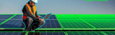 Technician seated with a laptop on a roof covered in solar panels